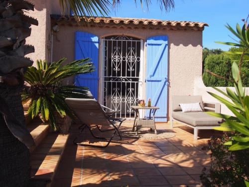 a patio with a blue door and a table and chairs at Villa Riviera, Sea view, Pool, Jacuzzi, Sauna, Walk to the beach in Sainte-Maxime