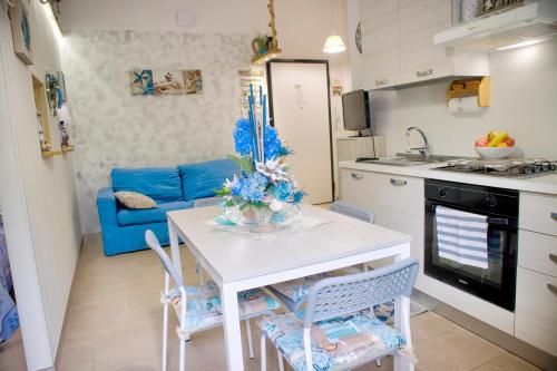 una cucina e un soggiorno con tavolo e sedie bianchi di casa vacanza sissi a Viareggio