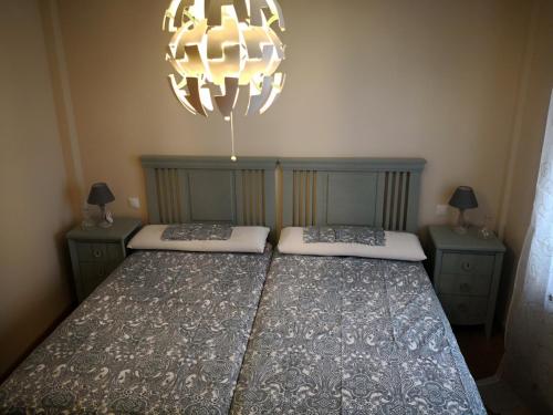 アレーナス・デ・サン・ペドロにあるApartamentos Torre de Gredosのベッドルーム1室(ベッド2台、シャンデリア付)