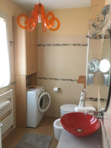 a bathroom with a red sink and a toilet at L`ATTICO Apartments in Civitanova Marche