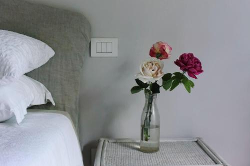 a vase of flowers on a table next to a bed at Country Home in Tuscany in Colle Val D'Elsa