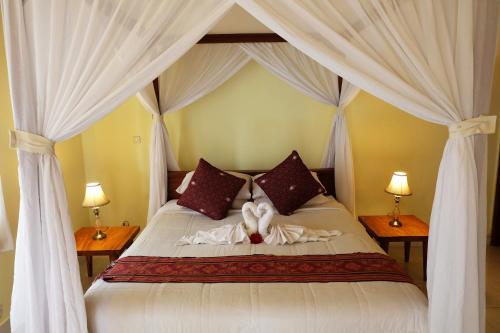 una camera da letto con un letto con due cuori sopra di Rendira Villa ad Ubud
