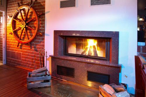 a fireplace with a wheel next to a brick wall at Hotel Seeschwalbe in Cuxhaven