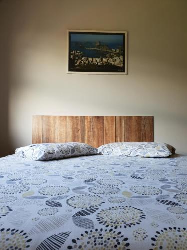 a bedroom with a bed with a wooden head board at Cantinho do Village in São Pedro da Aldeia
