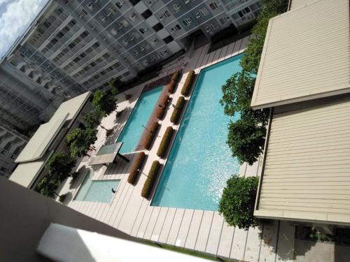 uma vista superior de uma piscina num edifício em Trees Residences by Jhoms 1BR with Balcony WiFi Netflix em Manila