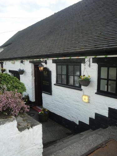 a white house with two windows and a door at The Dog & Partridge Country Inn in Ashbourne