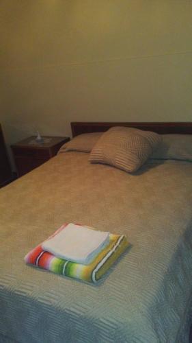 una pila de toallas sentadas encima de una cama en Grali home en Mendoza