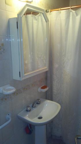 y baño blanco con lavabo y ducha. en Grali home en Mendoza