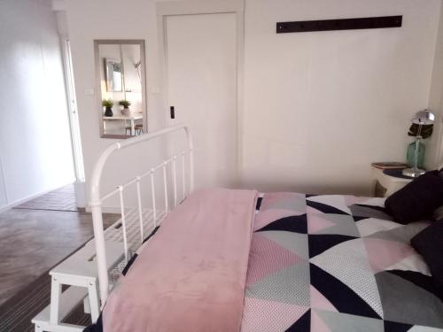 a bedroom with a white bed and a mirror at The Husky House or Little Husky Studio Suite in Huskisson