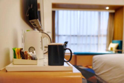 a coffee maker sitting on a desk next to a bed at Holiday Inn Express Chengdu Xindu by IHG in Chengdu