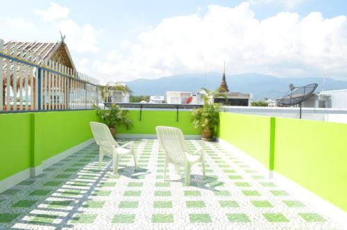 two white chairs sitting on top of a roof at i-smile in Chiang Mai