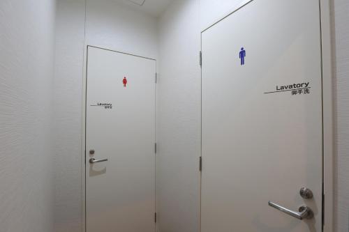 a bathroom with two doors with a mirror at EIWA PLACE HOTEL HAKATA - Former Hotel Ninestates Hakata in Fukuoka