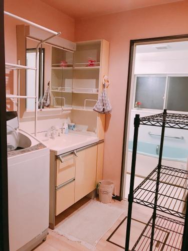 a bathroom with a sink and a mirror at HimawariRyokanひまわり旅館 in Okayama