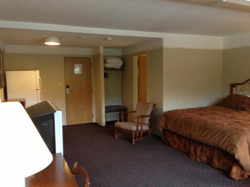 a hotel room with a bed and a chair at Moby Dick Inn in Prince Rupert