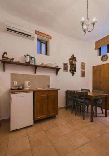 a kitchen with a table and a white refrigerator at Kristina´s rooms in Rhodes Town