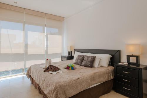 プラヤ・デル・カルメンにあるCentral Luxury Apartment Playa del Carmenのベッドルーム(大型ベッド1台、大きな窓付)