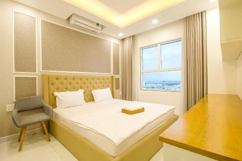 ein Schlafzimmer mit einem Bett, einem Stuhl und einem Fenster in der Unterkunft Sunrise City - 3 Bed Room - Full Furniture - City View in Ho-Chi-Minh-Stadt
