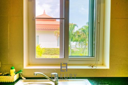- un évier de cuisine avec une fenêtre au-dessus d'un comptoir dans l'établissement 2 Bedroom Private Pool Villa B100, à Hua Hin