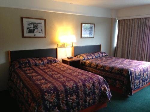 a hotel room with two beds and a lamp at Moby Dick Inn in Prince Rupert