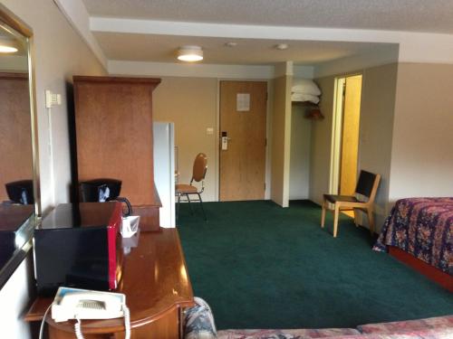 a hotel room with a bed and a desk and a television at Moby Dick Inn in Prince Rupert