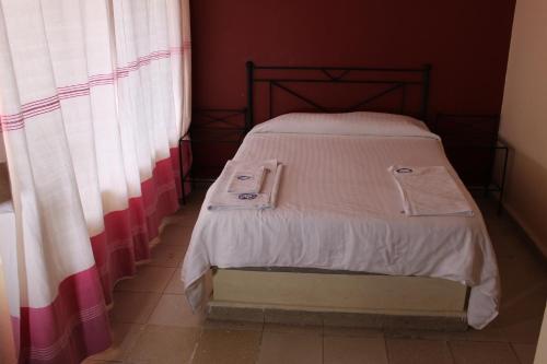 a small bed in a room with curtains at Hotel Casablanca Tuxtla in Tuxtla Gutiérrez