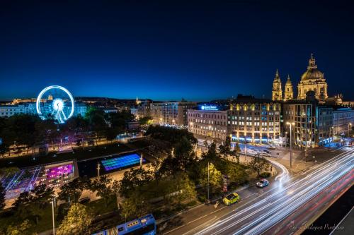 a city skyline at night with a ferris wheel at Eye of Budapest Penthouse in Budapest