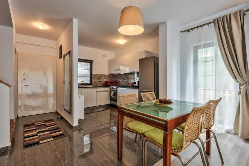 a kitchen and dining room with a table and chairs at Bucharest Airport Suites & Villas in Otopeni