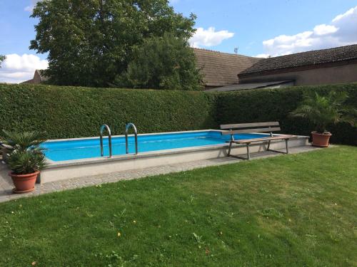 a swimming pool with a bench next to a yard at Landurlaub in Schiebsdorf in Kasel-Golzig