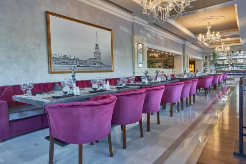 a long dining room with purple chairs and a long table at Rixos President Hotel Astana in Astana