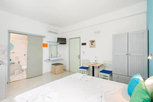 a bedroom with a white bed and a desk at Xenones Lindos in Líndos