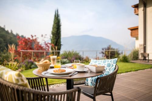 a table with food and drinks on a patio at Hotel Kiendl in Schenna