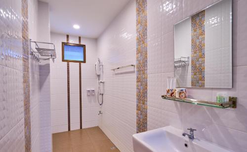 a bathroom with a sink and a shower with a tv at Mina Garden Villa Resort in Chiang Mai