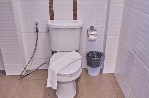 a bathroom with a toilet with a towel on it at Mina Garden Villa Resort in Chiang Mai