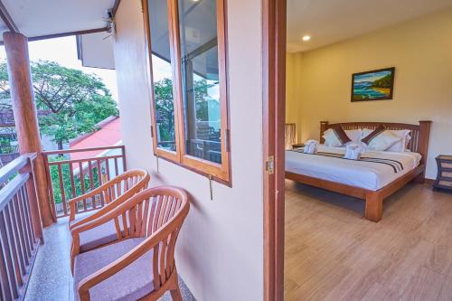 a bedroom with a bed and a balcony at Mina Garden Villa Resort in Chiang Mai