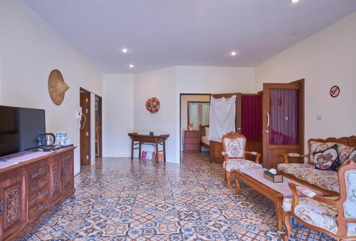 a living room with a couch and a tv at Mina Garden Villa Resort in Chiang Mai