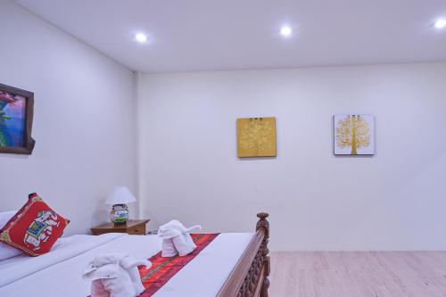 a bedroom with a bed with towels on it at Mina Garden Villa Resort in Chiang Mai