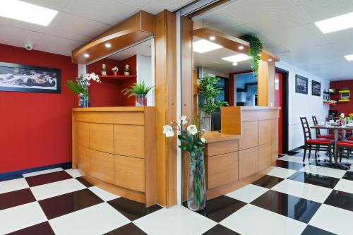 a restaurant with a counter with a vase of flowers at ENZO HOTELS Chalons en Champagne in Saint-Martin-sur-le-Pré