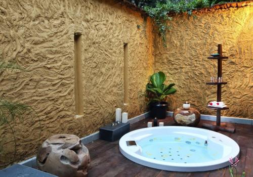 a bath tub in a room with a wall at Anantya By The Lake in Kalial