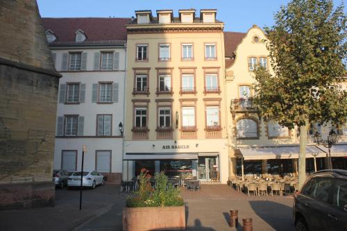 un gran edificio en una ciudad con mesas y sillas en lesboisjolis, en Colmar