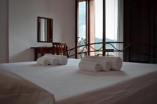 uma cama com três toalhas enroladas em cima em Nurazzolas em Villaputzu