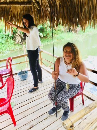 two women are sitting on a deck with an umbrella at Hoang Giang Homestay in Ninh Binh