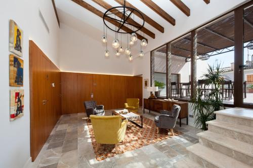 a living room with yellow chairs and a table at Ca'n Bestard - Adults Only in Lloseta