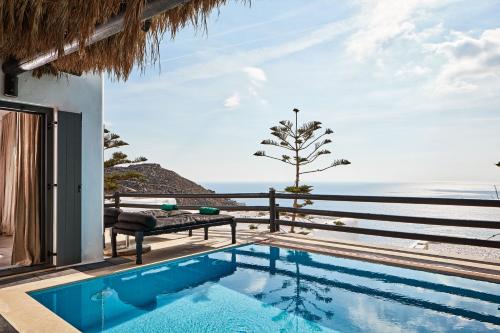 a villa with a swimming pool and a view of the ocean at Myconian Utopia Relais & Chateaux in Elia Beach