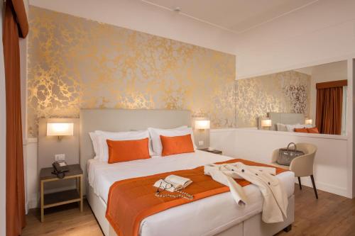 a bedroom with a large bed with orange pillows at Hotel Shangri-La Roma by OMNIA hotels in Rome