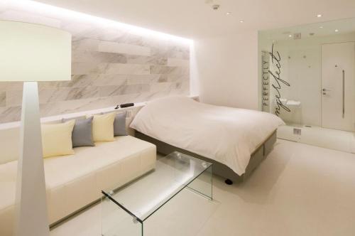 花巻市にあるホテル リスタ (大人専用) の白いベッドルーム(ベッド1台、ソファ付)
