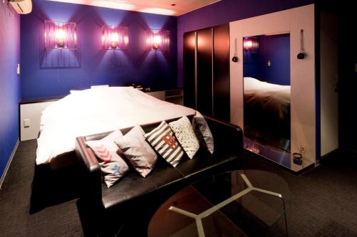 a bedroom with a bed with pillows and a mirror at HOTEL LYISTA (Adult Only) in Hanamaki