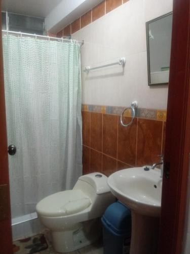 La salle de bains est pourvue de toilettes et d'un lavabo. dans l'établissement Hostal Intiwatana Inn, à Puno