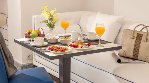 a tray of food and two glasses of orange juice at Hotel Shangri-La Roma by OMNIA hotels in Rome