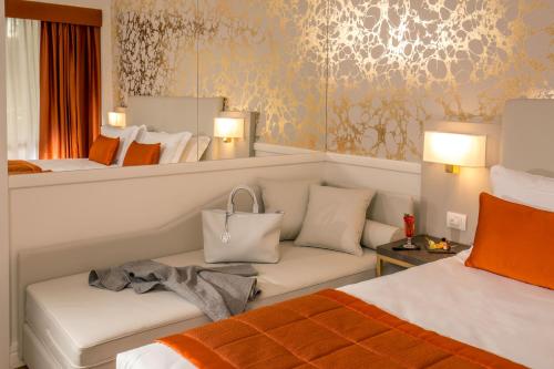 a bedroom with two beds and a couch and a mirror at Hotel Shangri-La Roma by OMNIA hotels in Rome