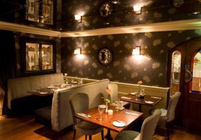 a restaurant with two tables and chairs in a room at The White House in Kinsale